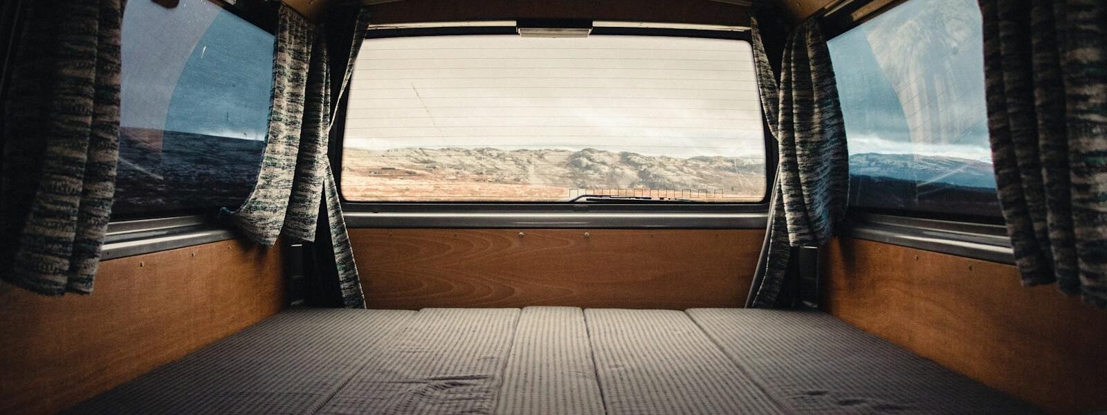 Comfortable and spacious camper van interior with scenic landscape view in Norway.