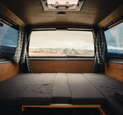 Comfortable and spacious camper van interior with scenic landscape view in Norway.