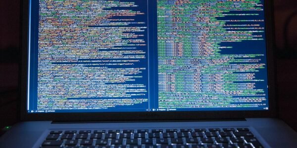 Laptop displaying source code with dual screens for software development.