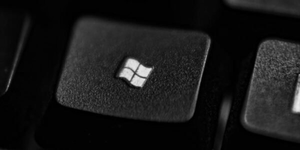 High-quality close-up of a Windows logo key on a black plastic keyboard.