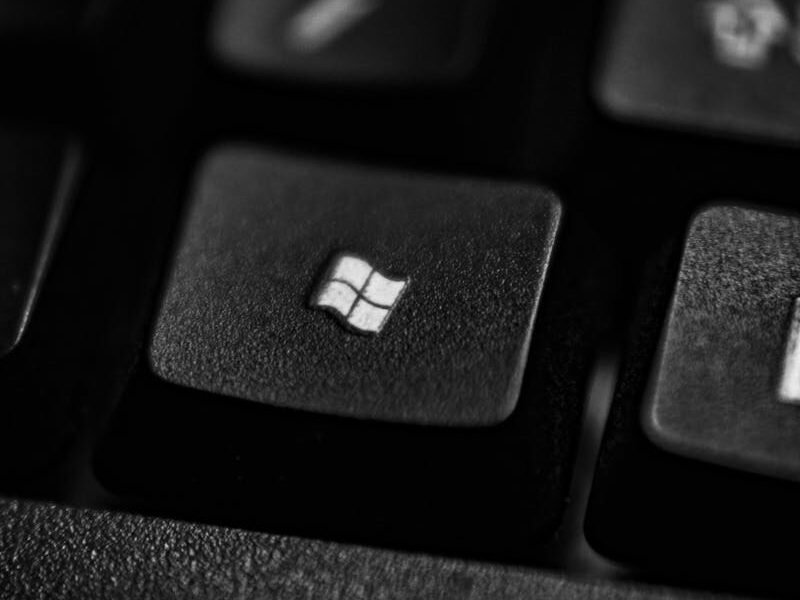 High-quality close-up of a Windows logo key on a black plastic keyboard.