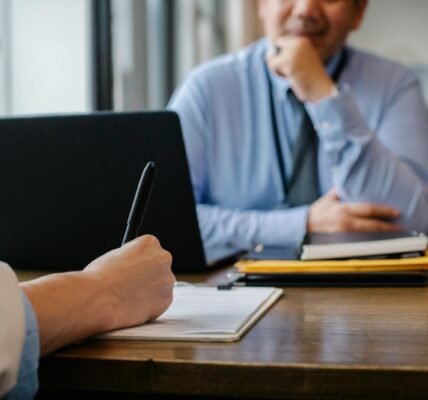 Crop anonymous female filling questionnaire when applying for job sitting in employer office