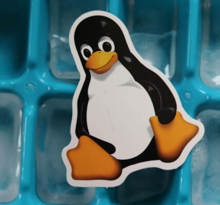 linux tux penguin mascot cutout lying on a tray with ice cubes
