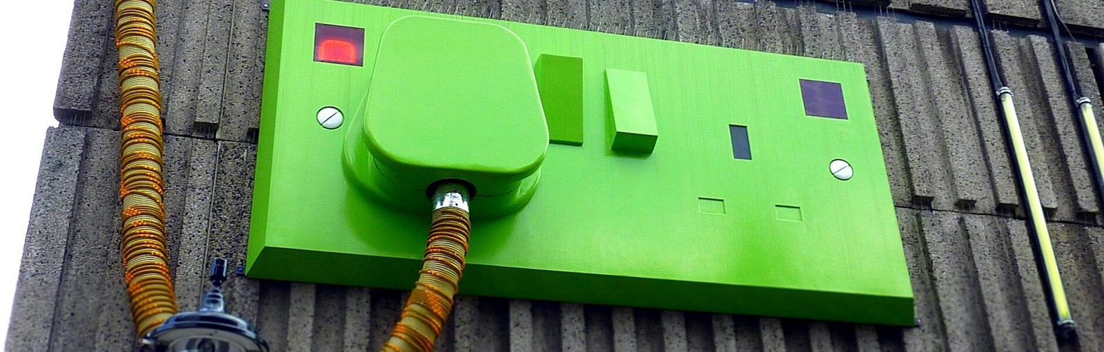 green rectangular corded machine on grey wall during daytime