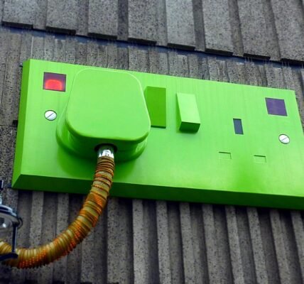 green rectangular corded machine on grey wall during daytime