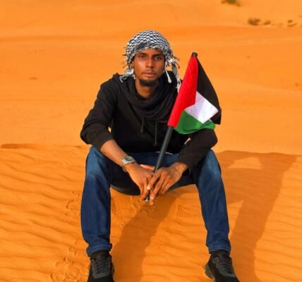 man in diffa desert holding palestinian flag