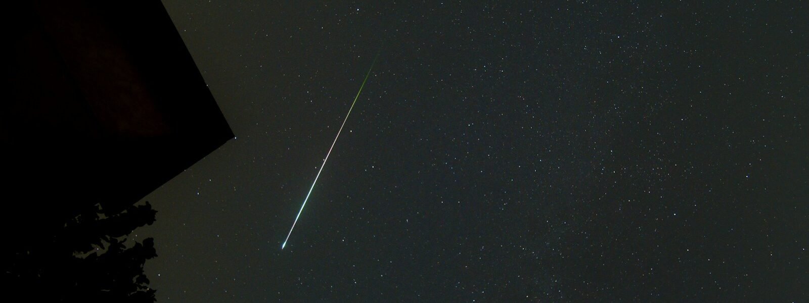 a shooting star is seen in the night sky