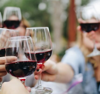 people tossing their clear wine glasses