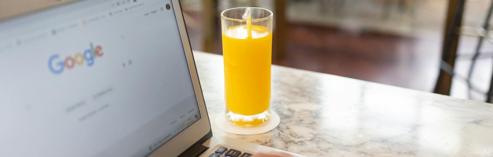 woman using a computer laptop near a glass of juice