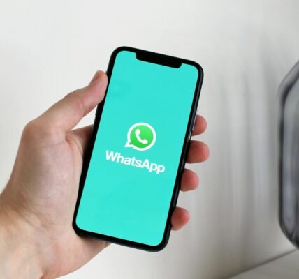 a person holding a cellphone with logo on the screen