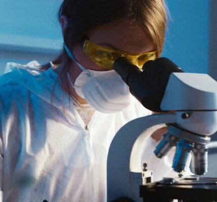 photo of woman looking through microscope