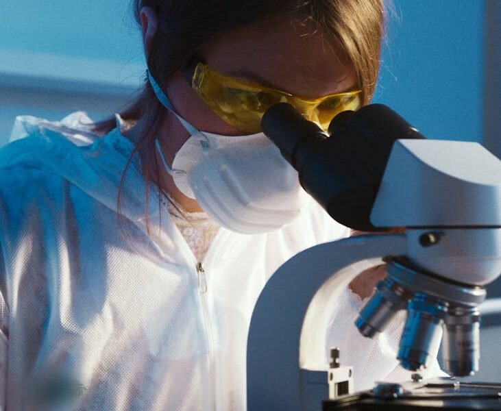 photo of woman looking through microscope