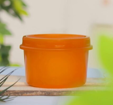 an orange plastic container on a wooden board