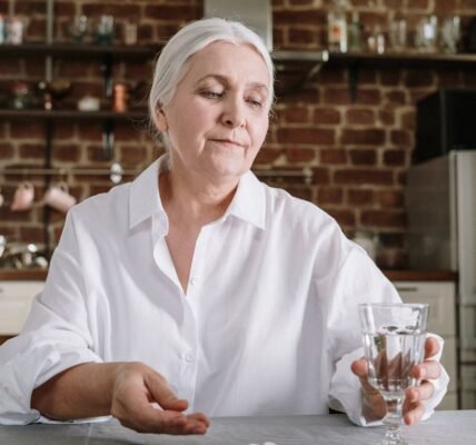 an elderly woman taking her medicines