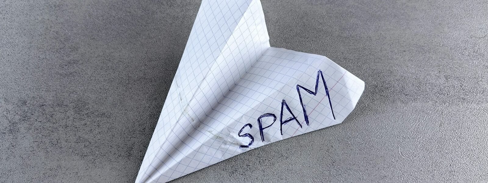 a paper airplane with the word spam written on it