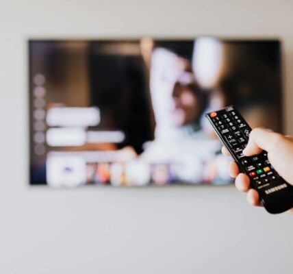 person pressing the button of a remote control